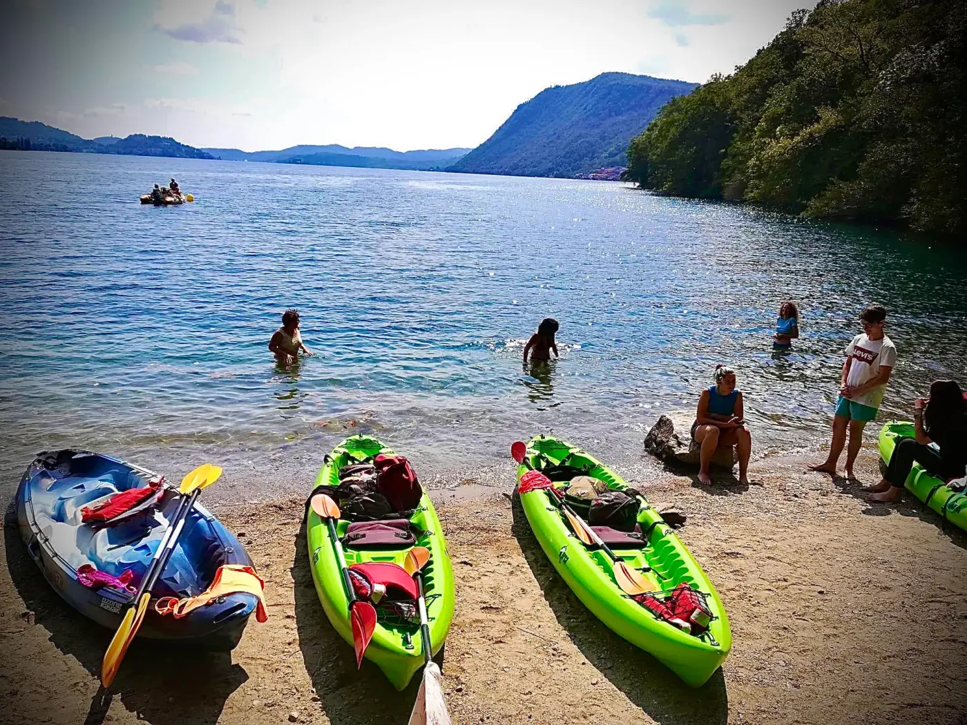 Kayak verdi sulla spiaggia del Lago d'Orta con bagnanti