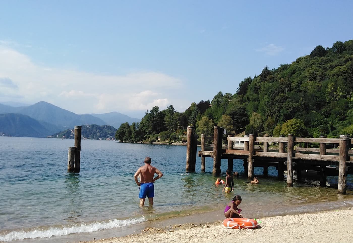 Spiaggia sul Lago d'Orta con pontile in legno e bagnanti